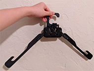 the image shows the same hanger but the 2 legs are spreaded out from each other. The 2 pictures highlight the lock mechanism on the hook slide down along the designed track.